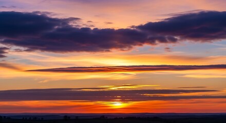 Fototapeta premium Vibrant orange sunset with cloudy sky