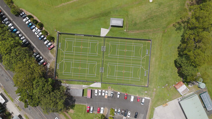 Naklejka premium Aerial Top Down View of Fenced Multi-Sport Courts and Parking Lot