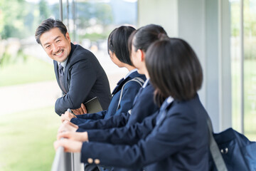 Fototapeta premium A male teacher talking to a student in the school hallway.