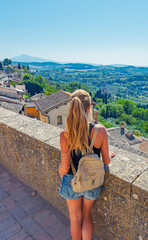 Naklejka premium young woman traveler contemplating the timeless panorama of montepulciano