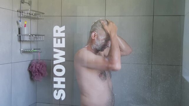 Man washing face under shower water, hygiene routine concept representing cleanliness, wellness, skin care and personal hygiene in modern bathroom
