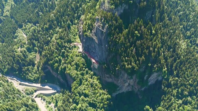 Altindere, Trabzon Province, Turkey. Sumela Monastery, a Greek Orthodox complex carved into a sheer cliff face, aerial drone view over dense coniferous forest and the winding Altindere Valley. Aerial