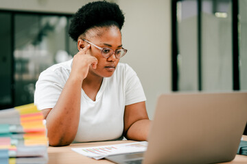 Obraz premium African american woman concentrating on laptop in office