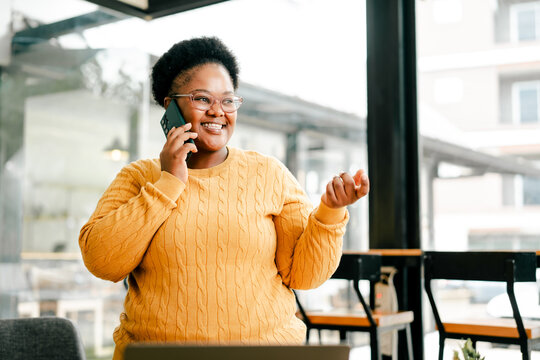 African american woman enjoying phone call in cafe