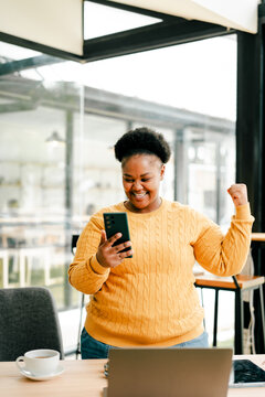 Woman celebrating good news checking smartphone content
