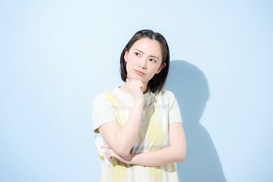 保育士や介護士、お母さんなど働く女性のトラブルが心配で悩む考える迷う困るポーズ、　転職や求人のイメージ