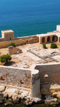 Vertical video. Kizkalesi, Mersin, Turkey. Aerial view of Maiden Castle fortress on island, medieval stone defensive walls with arched gallery, under clear blue sky.. Aerial View, Point of interest. 