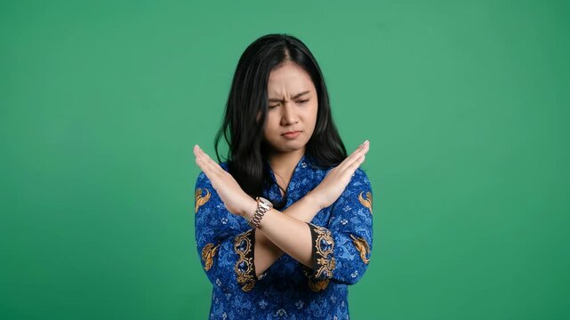 Indonesian Female Civil Servant in Batik Korpri Uniform Showing X Cross Hand Gesture to Reject or Say No for Anti Corruption Campaign and Professional Ethic Concept