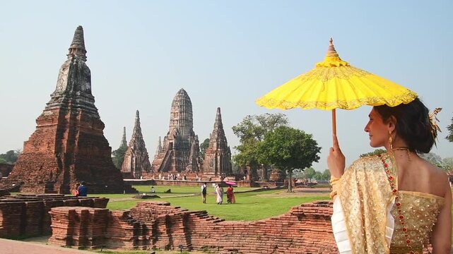 Thailand, Ayutthaya - march 15th, 2023: Woman in traditional Thai dress pose sightseeing visit ancient Buddha statue.Ayutthaya historical park. UNESCO World Heritage Site