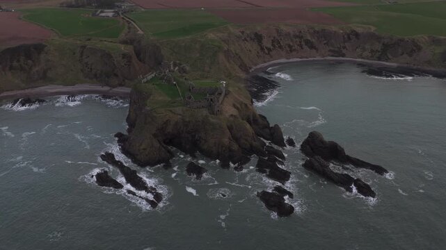 Majestic aerial perspective of the historic dunnottar castle, a ruined medieval fortress located upon a rocky headland on the coast of scotland