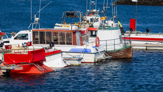 Fishing boats moored in a harbor marina in Iceland.