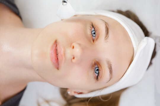 Beautician applying permanent makeup on lips of client
