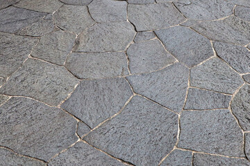 Obraz premium Dark grey stone path with irregular shapes and sizes.