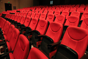 Fototapeta premium Rows of red velvet seats in a theater or cinema