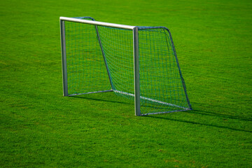 Fototapeta premium Football field shows empty goalpost. Football field with netting pattern. Football field supports training concept. Football field fits stadium environment.