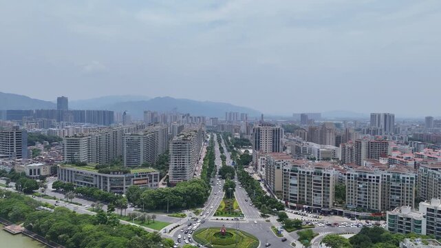 Modern city skyline with boulevard and distant mountains
