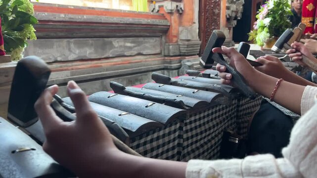 Close up of musicians playing Selonding Balinese Gamelan traditional percussion instrument in Bali, Indonesia