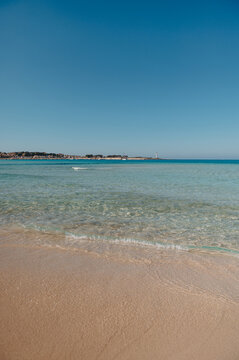 Clear shallow water, distant lighthouse in San Vito Lo Capo, Sicily
