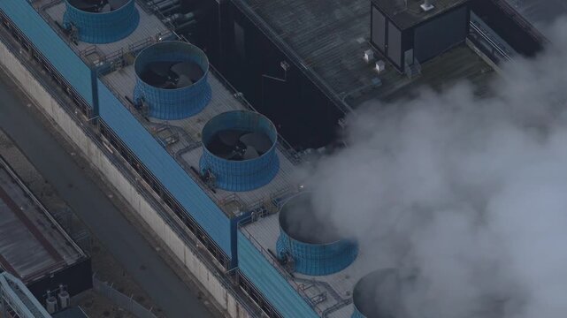 Aerial view of the massive google data center, showing its advanced cooling systems with water vapor rising from the cooling towers