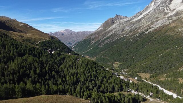 Aerial flyover over the forest near Arolla, Switzerland with a on a sunny summer day in the Swiss Alps