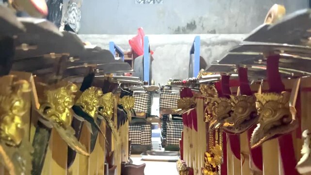 Symmetrical view of Balinese men playing Gamelan Gender Wayang with wooden mallets