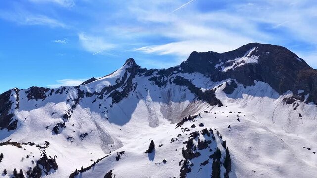 Drone 4K aerial forward flight with slight ascent toward snowy alpine cirque and rugged mountain peaks in the French Alps