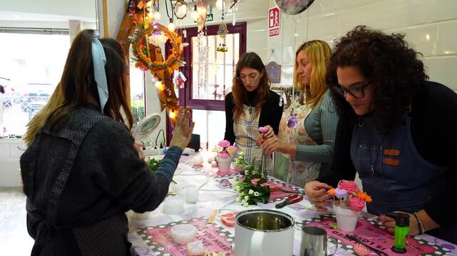Group of women participating in a candle making class, creating beautiful floral wax creations