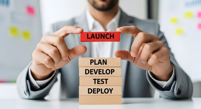 Project manager hands placing red launch block on stack symbolizing software development lifecycle planning and final deployment