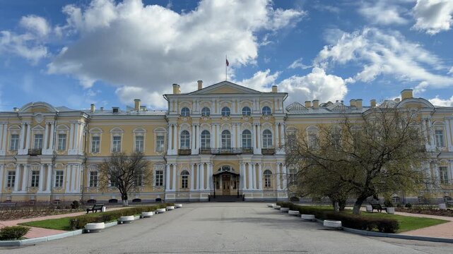Historic building with yellow and white classical architecture, featuring trees and benches in front, shown in three connected frames highlighting details