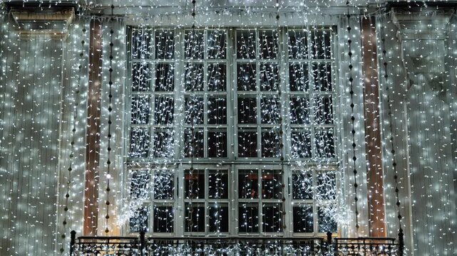 City building window illuminated with bright Christmas and New Year lights at night