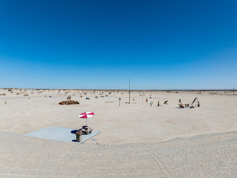 Drone shot of a desert picnic site with a red and white umbrella