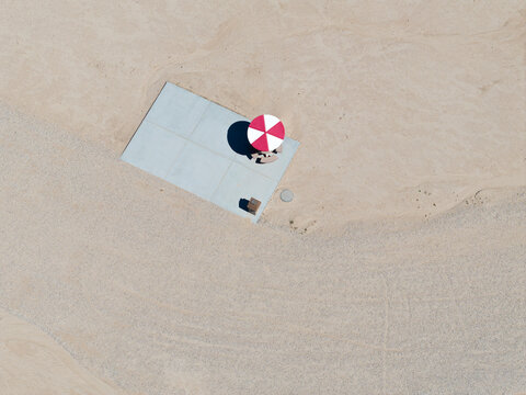 Overhead perspective of single picnic table and umbrella in desert