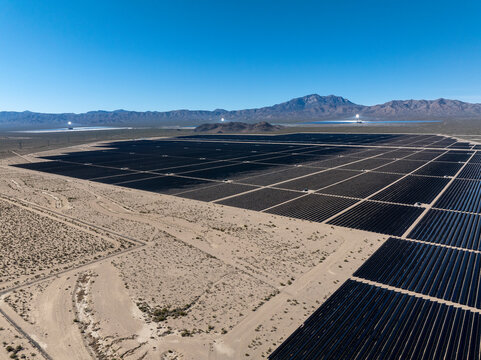 Drone perspective rows of photovoltaic solar panels desert terrain