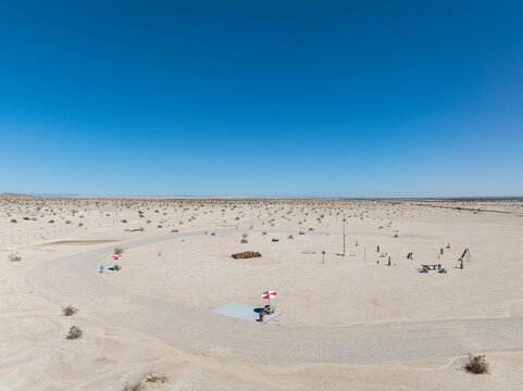 Elevated view circular desert picnic area with red and white umbrellas