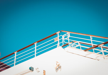 low angle view of white cruise ship railings and deck against a clear blue sky with copy space © AJITH.A