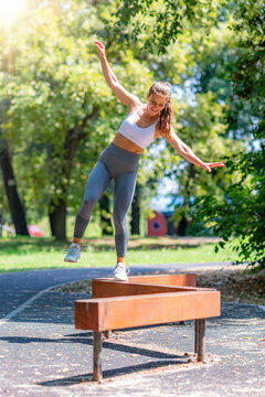 Balancing on narrow wooden obstacle, practicing stability, coordination and functional outdoor training.