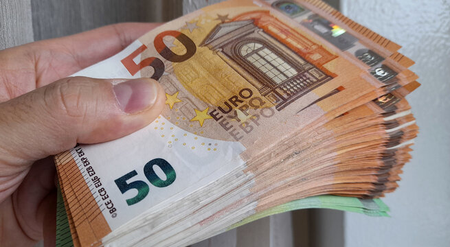 Banconote da 50 euro nelle mani di un uomo - business	