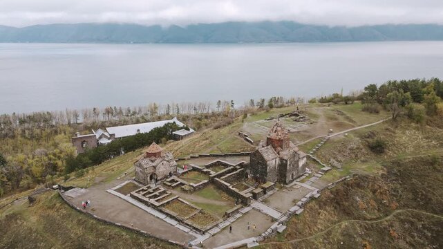 Aerial panning view Sevanavank monastic complex. Lake Sevan in the Gegharkunik Province of Armenia. Group of tourist visit popular travel sightseeing attraction