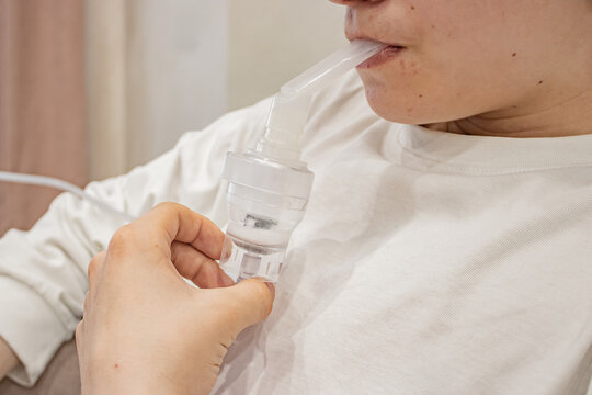 A close-up view of a person using a nebulizer, demonstrating the respiratory treatment process intended for asthma and other respiratory conditions.