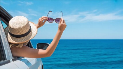 Fototapeta premium Woman wearing sunglasses and hat looking out at sea