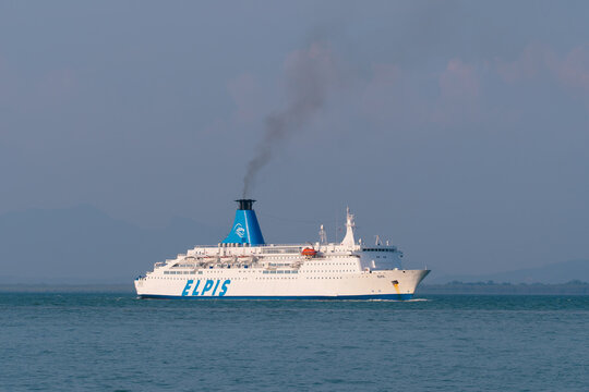 PENANG, MALAYSIA - MAR 19, 2026: Wide view of Elpis passenger ferry sailing across calm sea with blue sky and distant coastline.