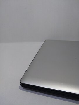 Closed silver laptop on a clean white surface, featuring a sleek modern design.