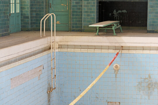 Verlassenes Hallenbad mit leerem Schwimmbecken