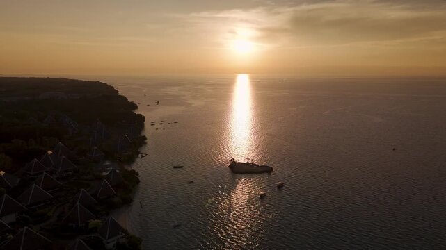 Drone ascends and pulls back over Panglao Island and the ocean at sunset in Bohol