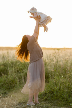 mother hugs her baby at sunset in summer