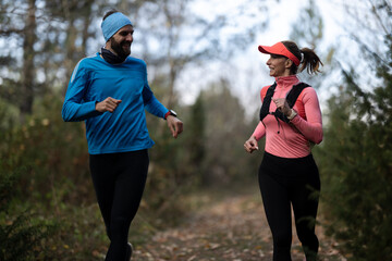 Fototapeta premium Couple Running Together On Forest Trail Outdoor Fitness Jogging In Cold Weather Active Lifestyle