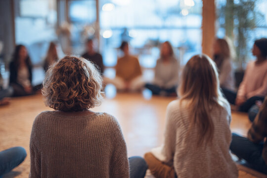 women circle and sisterhood support concept, female participants sitting together in workshop or retreat