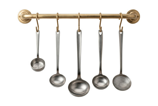 Stainless steel ladle set hanging on brass rail isolated. Professional kitchen organization.