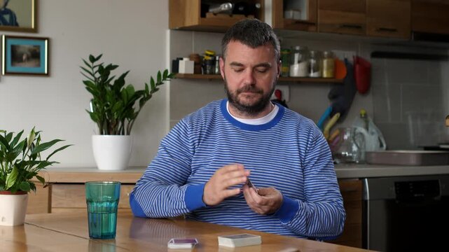Focused man playing solitaire card game at home