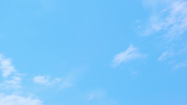 A blue sky timelapse video footage featuring soft stratocumulus clouds drifting across a bright atmosphere, capturing peaceful weather, natural light, airy textures, and serene daytime scenery. 4k.
